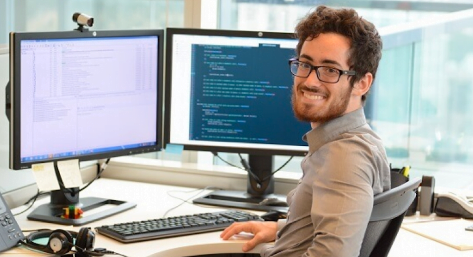 Man sitting on chair with two computers