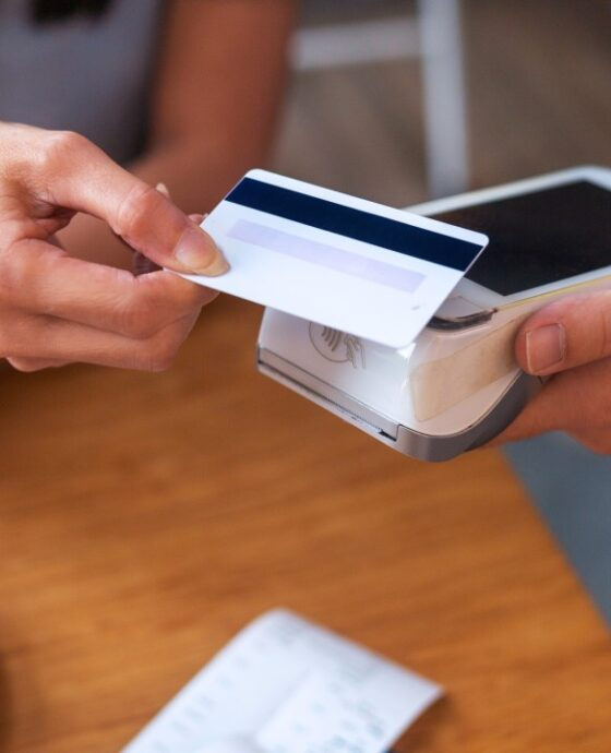 (What is epos) Person holding a credit card over a credit card reader