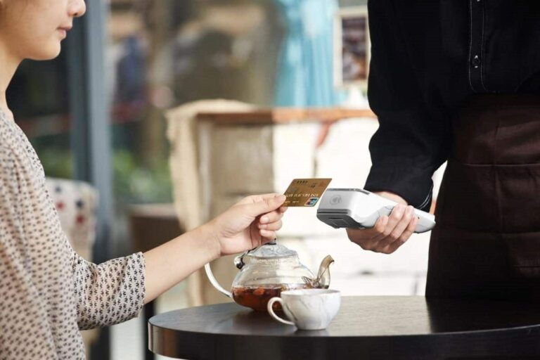 Woman holding credit card and man holding card payment machine